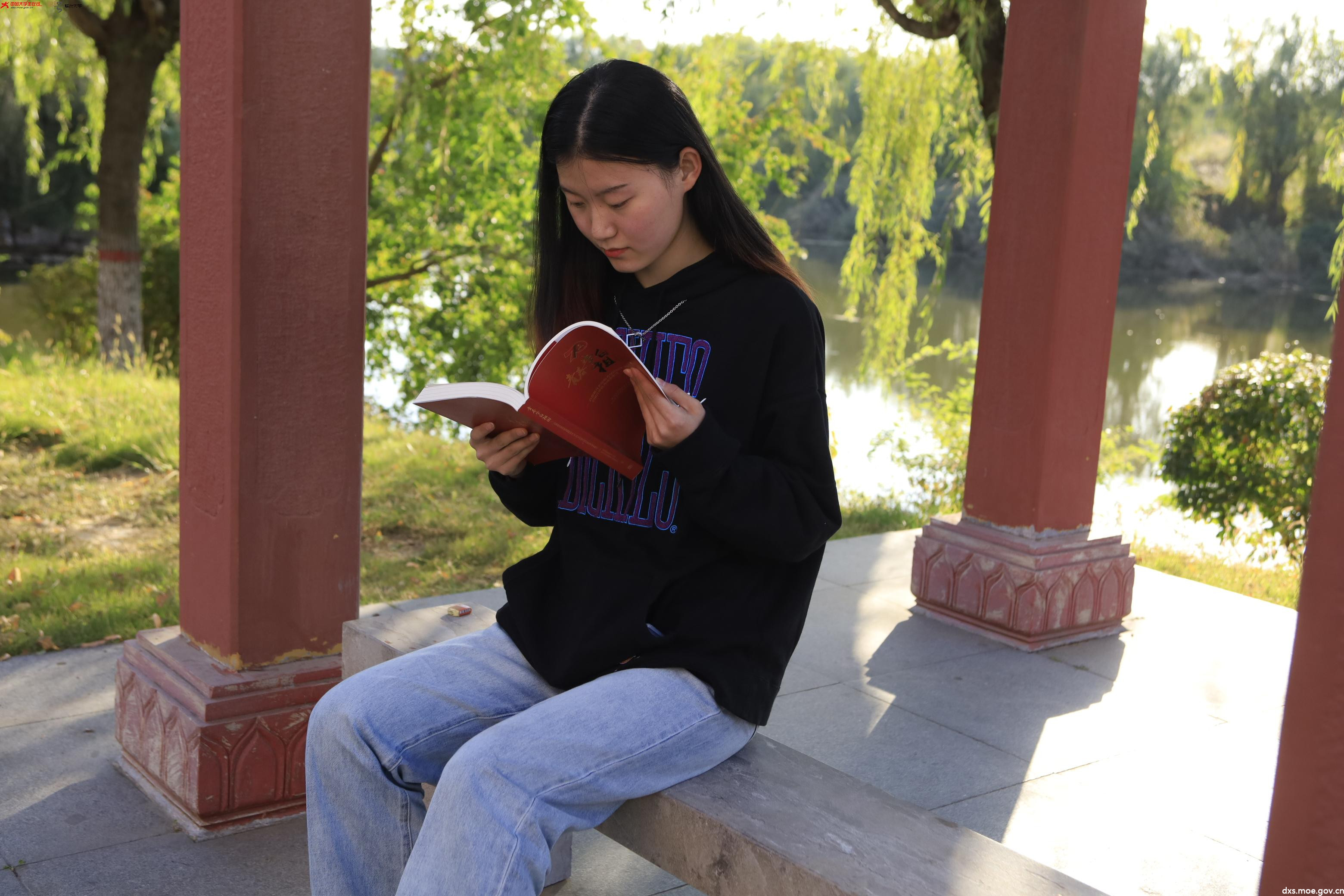 临沂大学学子在校园中阅读《青春告白祖国》。